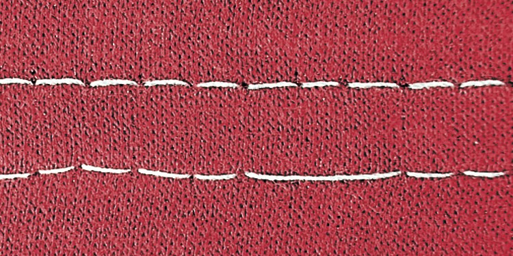 Close-up of a red fabric showing skipped stitches